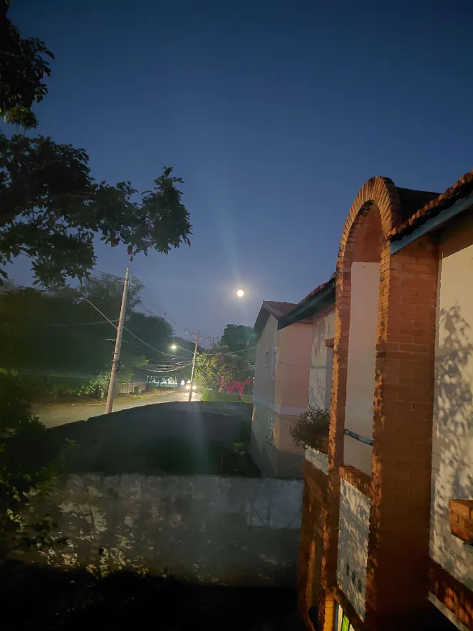 A full moon rising over the street that night